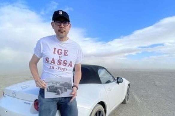 Oliver Wang leaning on car in desert